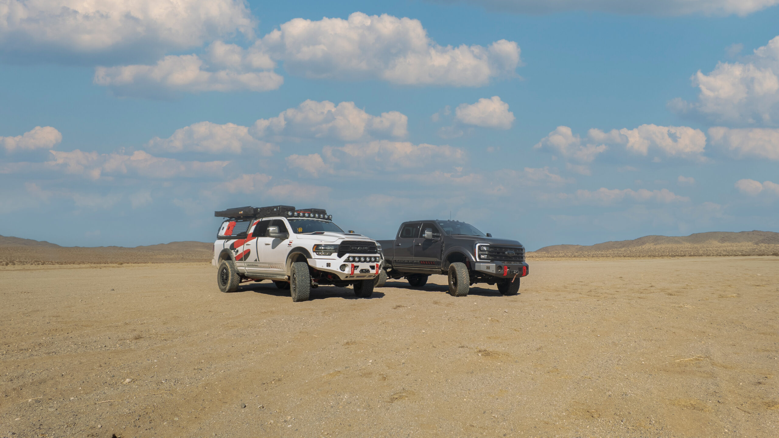RAM 3500 pickup and Ford 550 in desert with blue skies